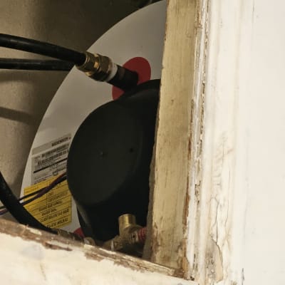 חיבורים וצינורות של דוד שמש בתוך מסגרת עץ