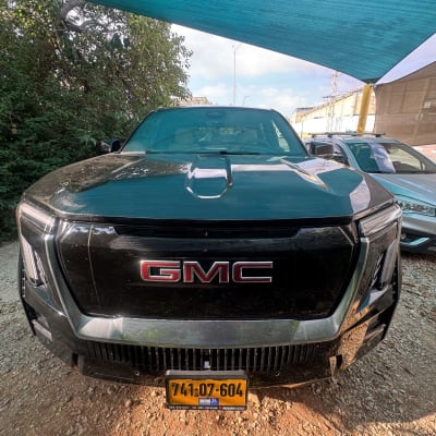 רכב GMC שחור חונה תחת כיסוי כחול