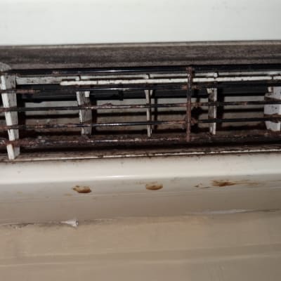 גריל מזגן עם חלודה ולכלוך נראה בבירור