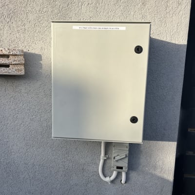 ארון חשמל מותקן על קיר חיצוני עם חיווט.