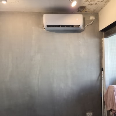 מזגן מותקן על קיר עם תאורה מעליו