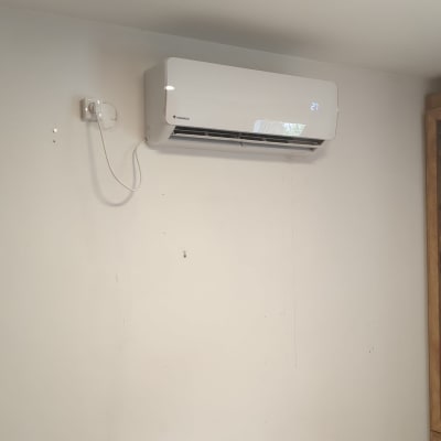 מזגן מותקן על קיר ליד ארון עץ