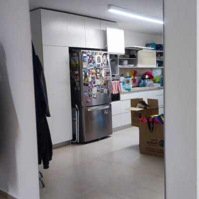 מראה גדולה משקפת מטבח עם מקרר וארגזים