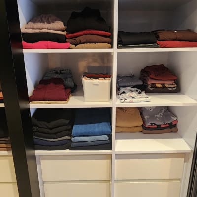 ארון בגדים מסודר עם בגדים מקופלים על מדפים