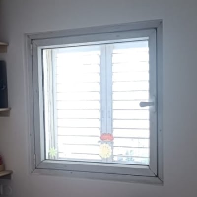 חלון עם תריסים סגורים בחדר פנימי