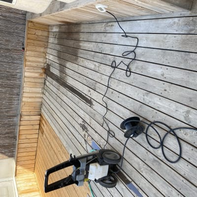 מכונת שטיפה בלחץ על דק עץ עם כבל חשמל