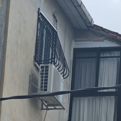 מסגרת מתכת שחורה סביב חלון עם מזגן חיצוני