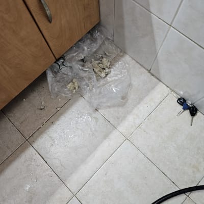 רצפה רטובה עם שאריות חומרי בנייה ליד ארון מטבח