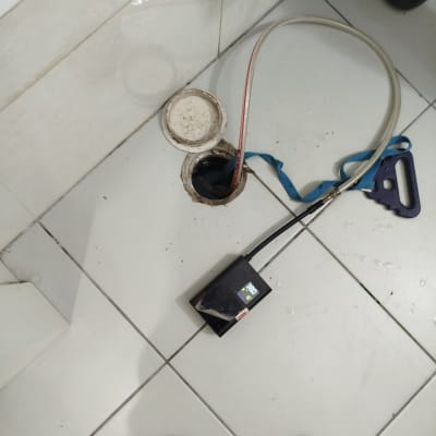 כלי עבודה וצינור ליד פתח ביוב על רצפה