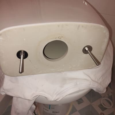 מיכל הדחה מונח על אסלה עם ברגים חשופים