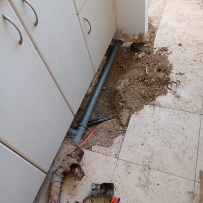 צינור פלסטיק חדש מותקן ברצפה, צינור ישן חלוד מפורק.