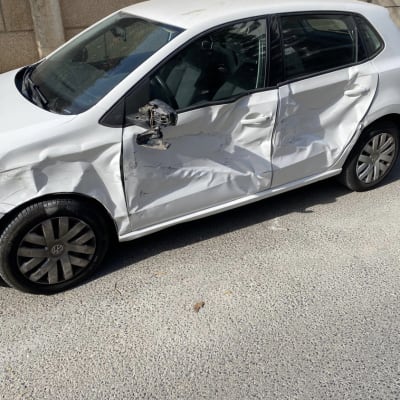 רכב לבן עם נזק כבד לדלת ולמראה