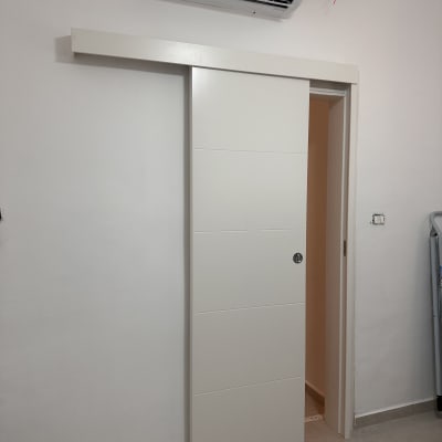 דלת הזזה לבנה מתחת למזגן