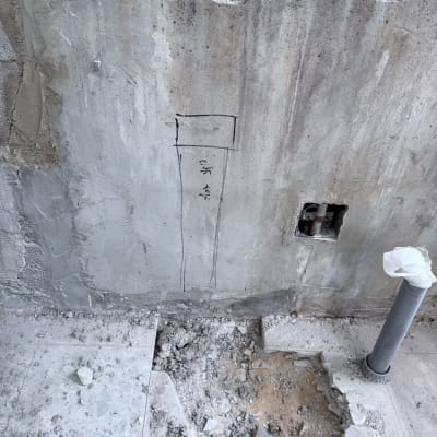 קיר בטון עם חור, צינור פלסטיק ושרטוט בעיפרון