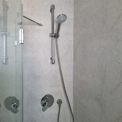 ראש מקלחת וכפתורי שליטה על קיר אריחים