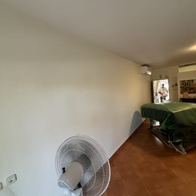 חדר עם קיר צבוע ומאוורר עומד