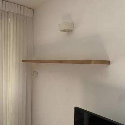 מדף עץ מותקן על קיר לבן