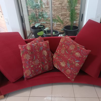 ספה אדומה עם כריות דקורטיביות בפרחים