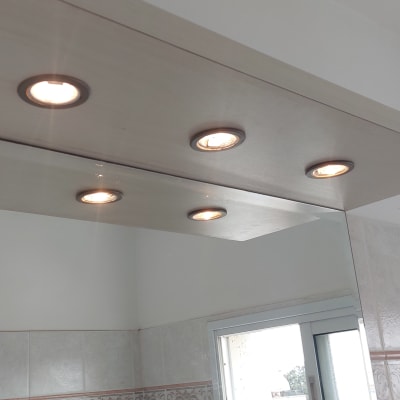 חמישה פנסי תקרה עגולים מותקנים בלוח עץ