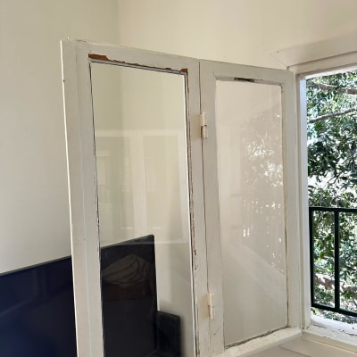 חלון זכוכית פתוח עם מסגרת עץ לבנה