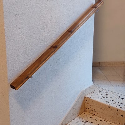 מסגרת עץ תלויה על קיר ליד מעקה עץ