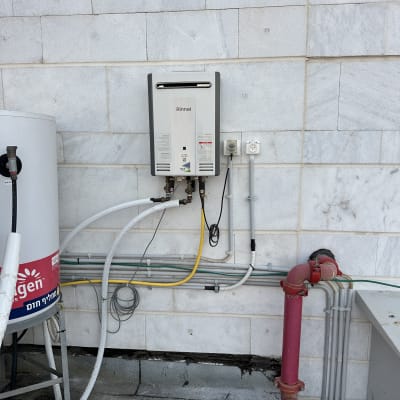 מערכת חימום מים עם צינורות וחיבורים על קיר חיצוני