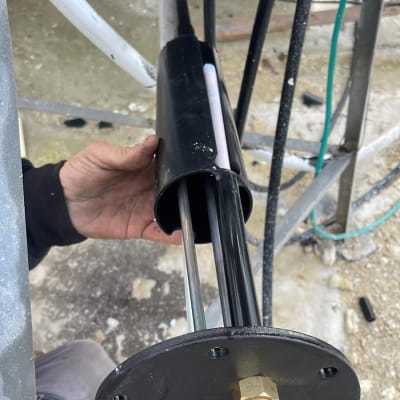 ידיים מחזיקות רכיב מתכת של דוד שמש עם חוטים חשמליים