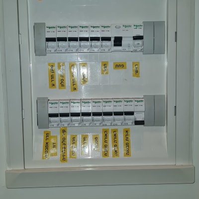לוח חשמל עם מפסקים ותוויות צהובות