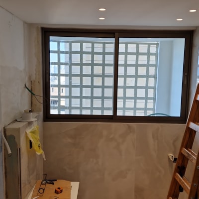 חלון אלומיניום עם מסגרת כהה בחדר שיפוצים