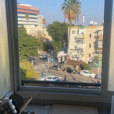 חלון אלומיניום עם נוף עירוני ברקע