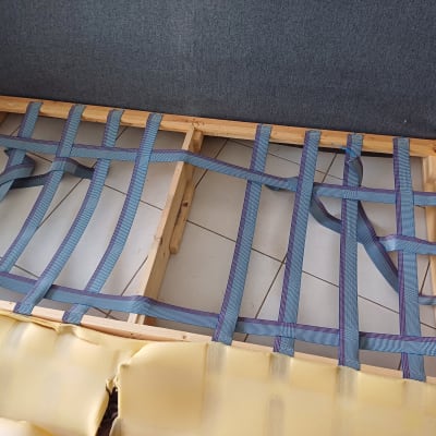 רצועות תמיכה כחולות על מסגרת עץ של ספה