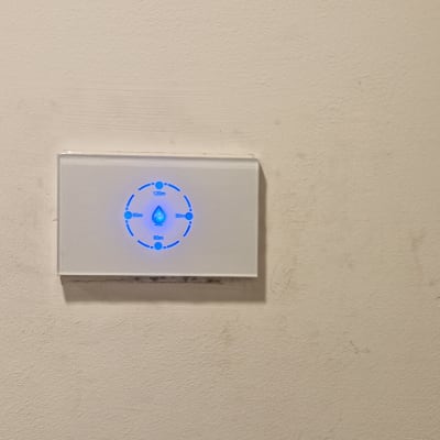 מתג חשמלי עם תאורה כחולה על קיר