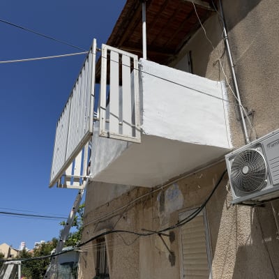 מרפסת עם מזגן על קיר חיצוני של בניין