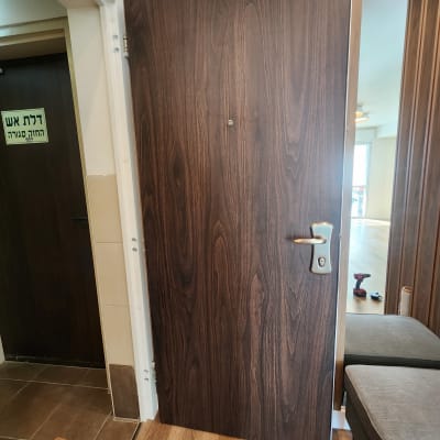 דלת עץ עם ידית מתכת וכלי עבודה על הרצפה