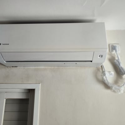 מזגן מותקן על קיר עם חיבור לחשמל