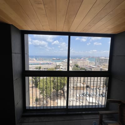 מרפסת עם נוף לים ומבנים, ללא אלומיניום נראה לעין