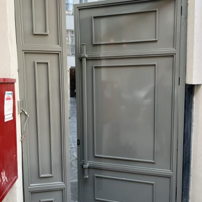 דלת מתכת אפורה עם מסגרות דקורטיביות