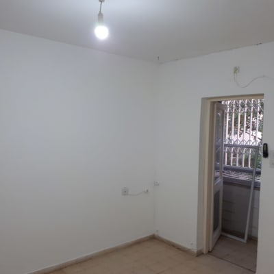 חדר עם קירות צבועים בלבן ונורה דולקת