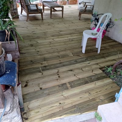 רצפת עץ חדשה עם כיסאות פלסטיק בגינה