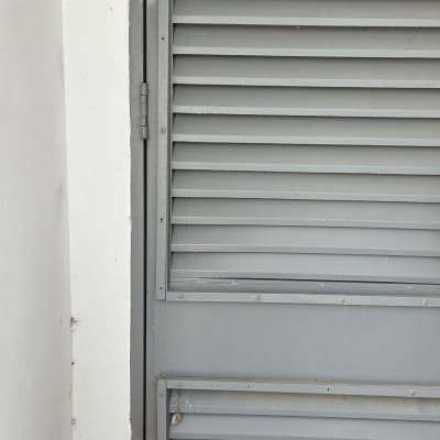 דלת מתכת אפורה עם תריסים