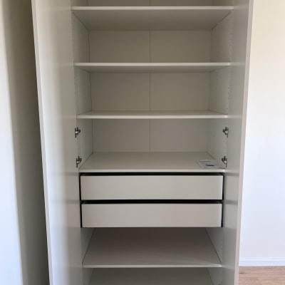 ארון לבן עם מדפים ומגירות פתוחות