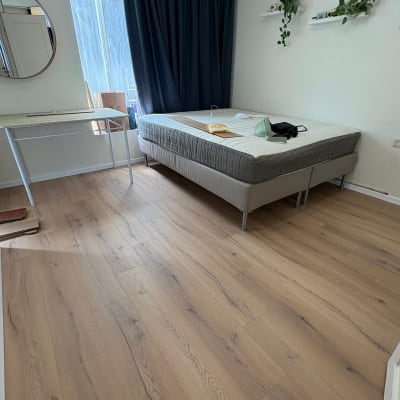 רצפת פרקט בחדר שינה עם מיטה ושולחן