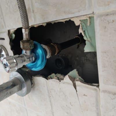 צנרת מים עם חיבורי ברז בקיר שבור