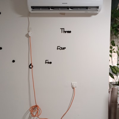 מזגן מותקן על קיר עם כבל חשמל כתום