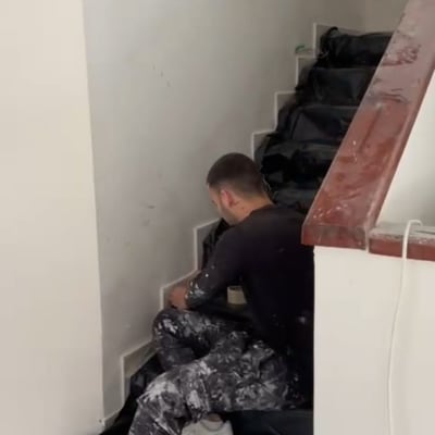 אדם צובע מדרגות עם ציוד צביעה