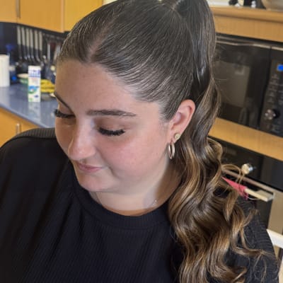 אישה עם שיער אסוף בקוקו גבוה ואיפור עדין