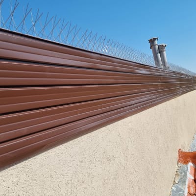 גדר מתכת חומה עם דוקרנים על גג