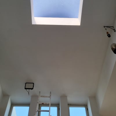 תקרה עם חלון סקיילייט וסולם צבוע לבן