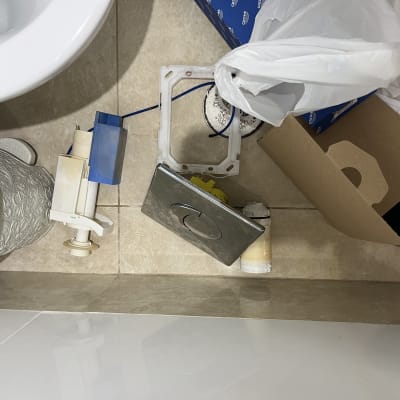 חלקי אינסטלציה וכלים על רצפת חדר אמבטיה