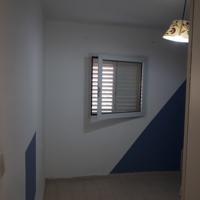 קיר צבוע בלבן וכחול עם חלון פתוח